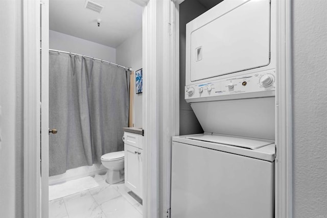 laundry room with stacked washing maching and dryer