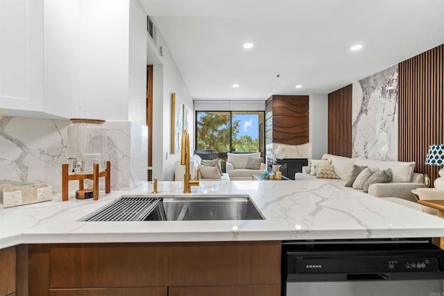 kitchen with white cabinets, sink, stainless steel dishwasher, decorative backsplash, and light stone counters