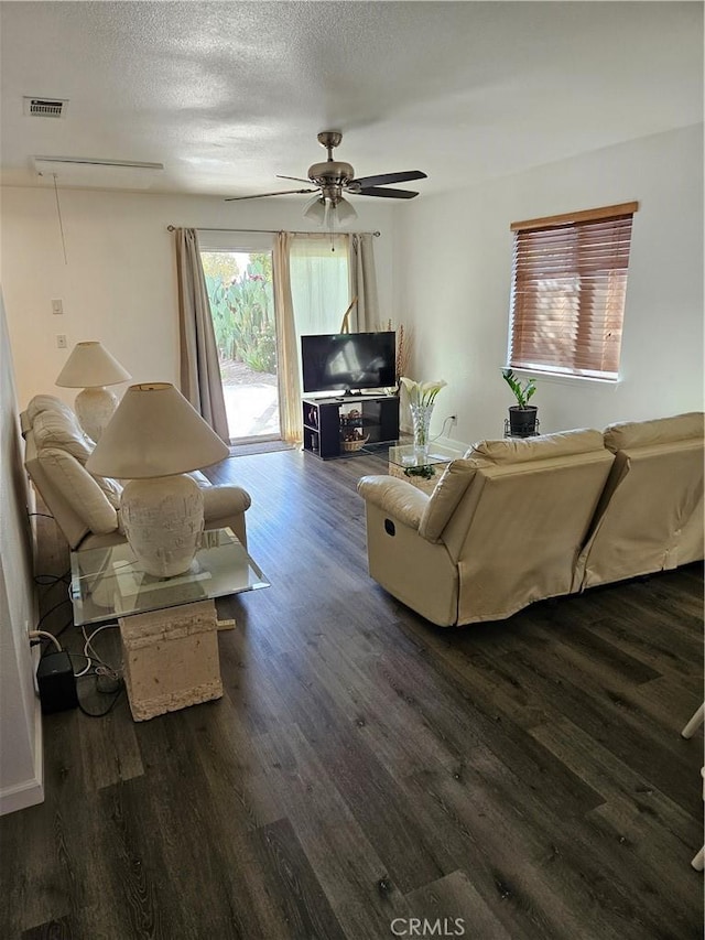 living room featuring a textured ceiling, dark hardwood / wood-style floors, and ceiling fan