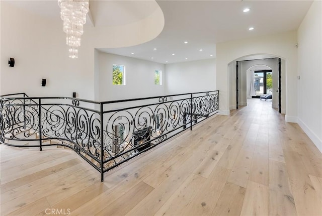 hallway featuring light hardwood / wood-style floors and a notable chandelier