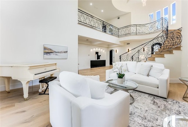 living room with hardwood / wood-style flooring and a towering ceiling