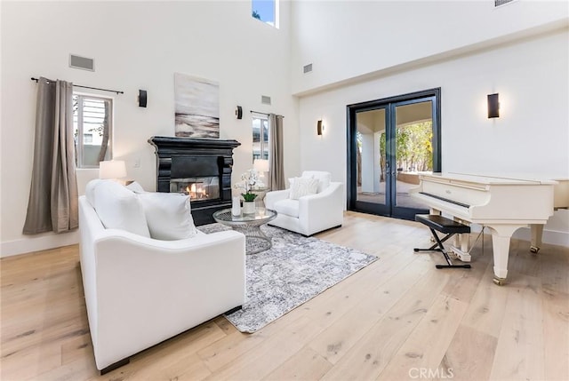 living room with light hardwood / wood-style flooring and a high ceiling