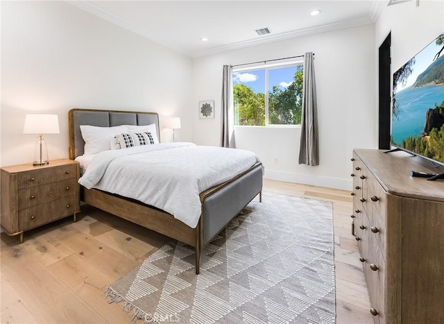 bedroom featuring light wood-type flooring and crown molding