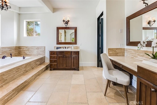 bathroom with vanity, a relaxing tiled tub, and a chandelier