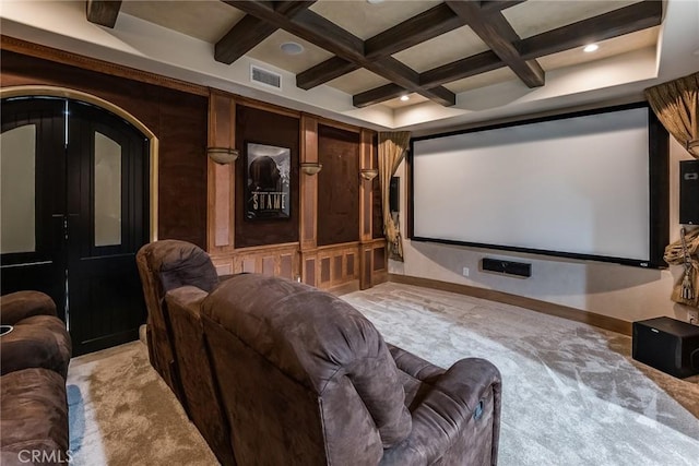 carpeted home theater room with beamed ceiling and coffered ceiling