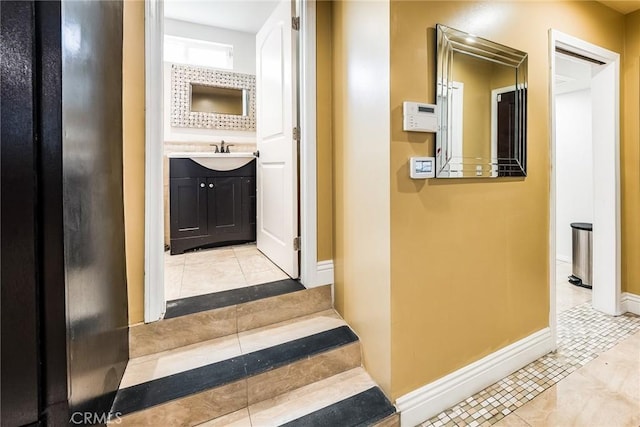 corridor with light tile patterned floors and sink