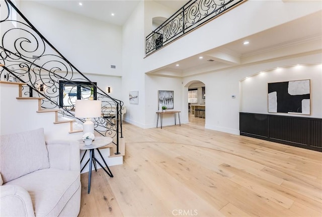 interior space with hardwood / wood-style flooring, beam ceiling, and ornamental molding