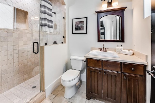 bathroom featuring toilet, tile patterned floors, a shower with door, and vanity