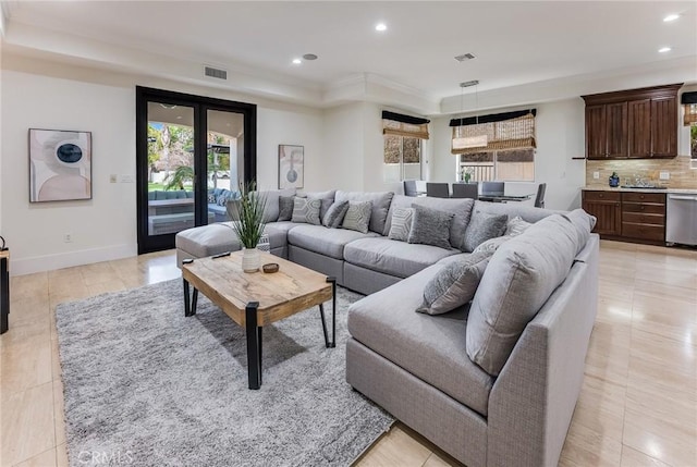 living room featuring a raised ceiling, french doors, a wealth of natural light, and crown molding