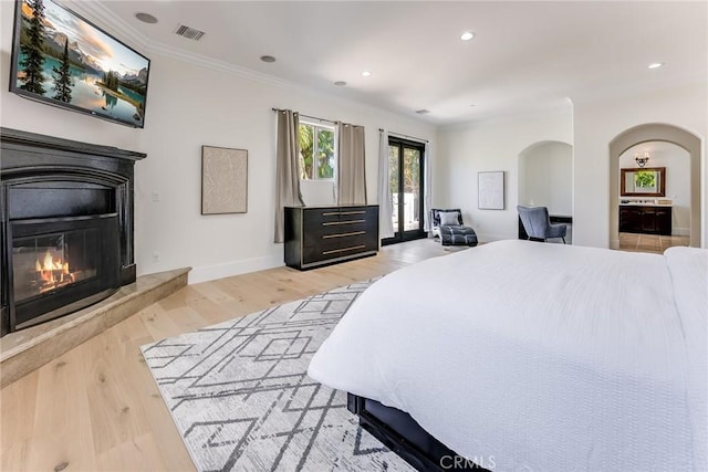 bedroom with light hardwood / wood-style floors and ornamental molding