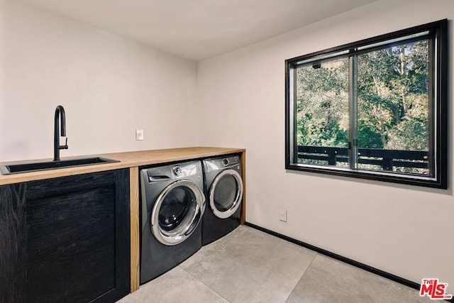 washroom featuring washer and clothes dryer, sink, and a healthy amount of sunlight