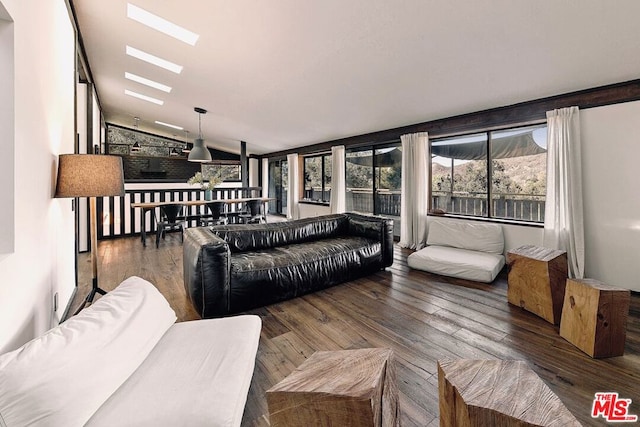 living room featuring dark hardwood / wood-style floors and lofted ceiling with skylight