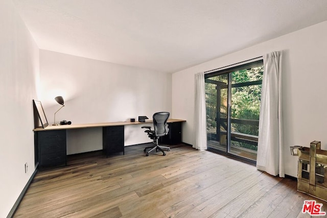 home office featuring built in desk and wood-type flooring