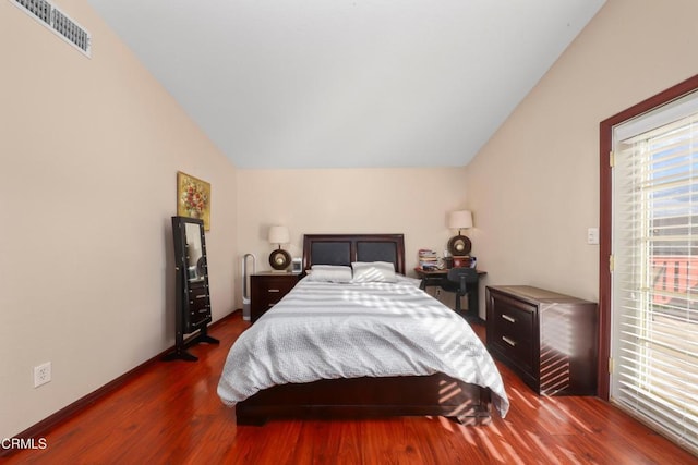 bedroom with hardwood / wood-style floors and lofted ceiling