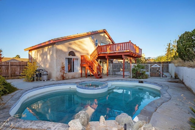 view of pool with an in ground hot tub and a deck