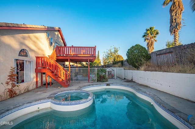 view of swimming pool with an in ground hot tub and a wooden deck