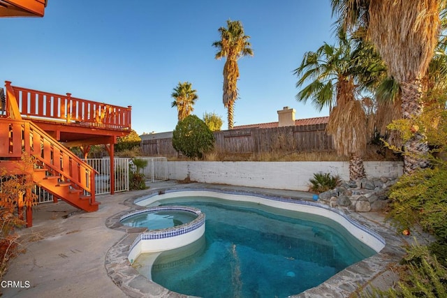 view of pool with an in ground hot tub and a deck