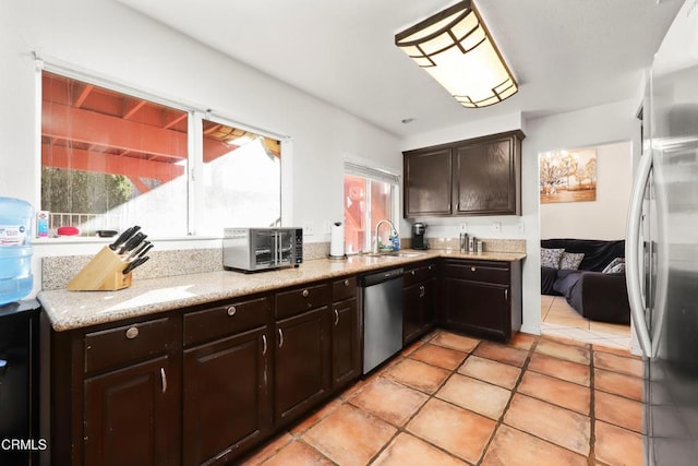 kitchen featuring plenty of natural light, dark brown cabinets, sink, and appliances with stainless steel finishes