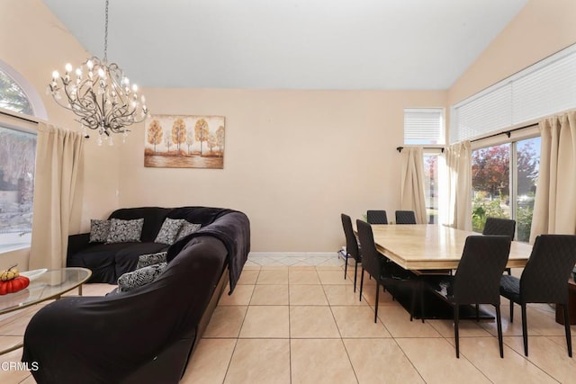 dining space with a notable chandelier, light tile patterned flooring, and lofted ceiling