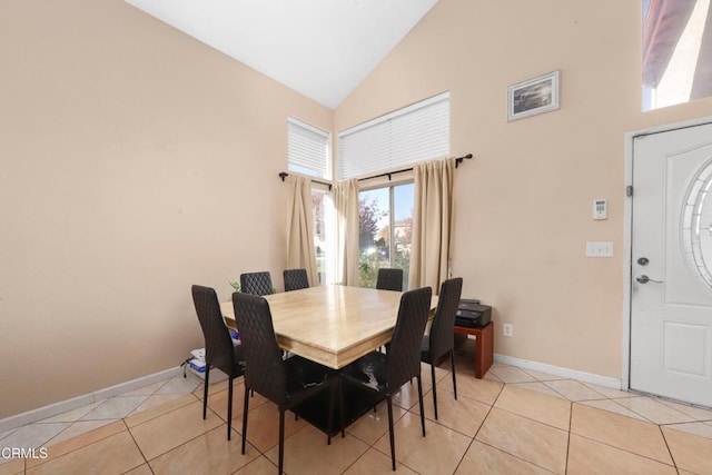 dining area with light tile patterned floors and high vaulted ceiling