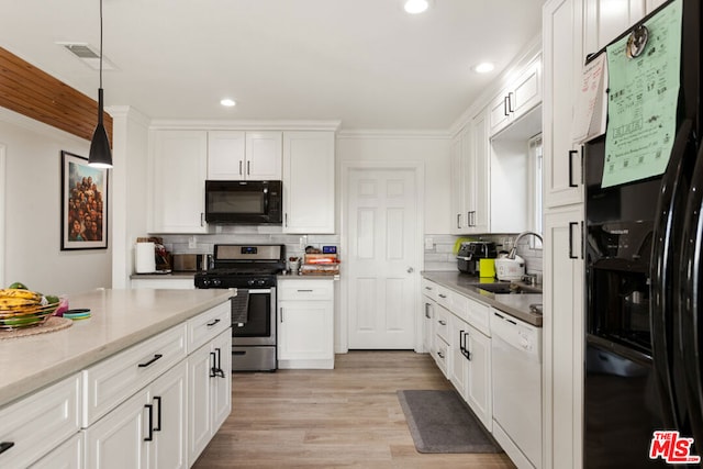 kitchen featuring sink, white cabinetry, hanging light fixtures, and black appliances