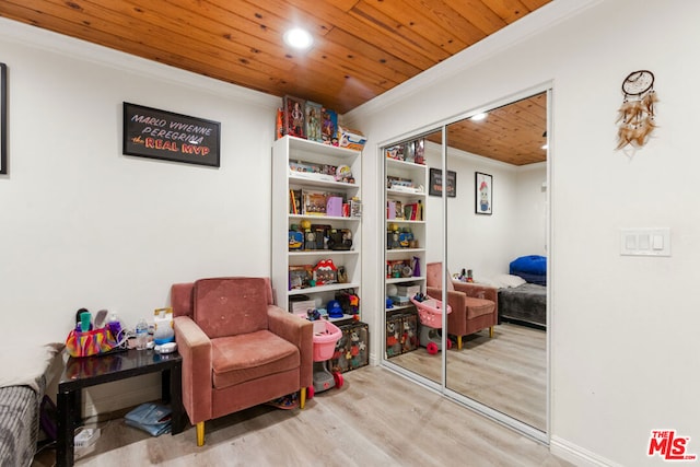 sitting room with light hardwood / wood-style floors, ornamental molding, and wood ceiling