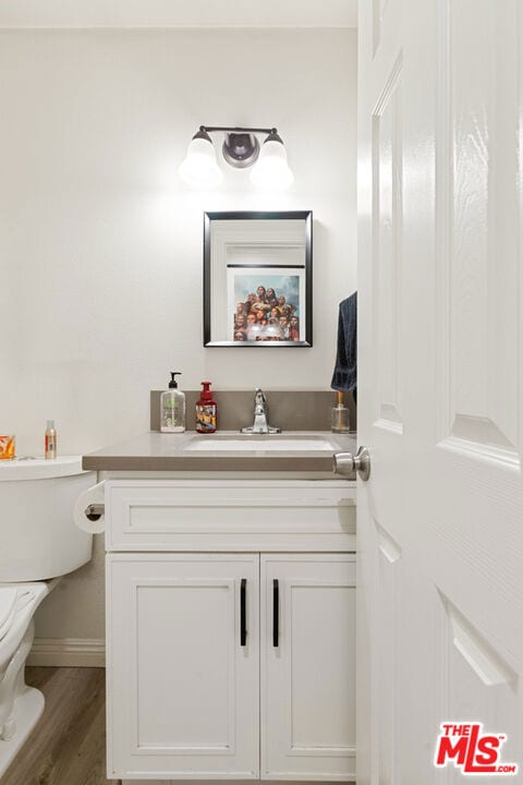 bathroom with vanity, wood-type flooring, and toilet