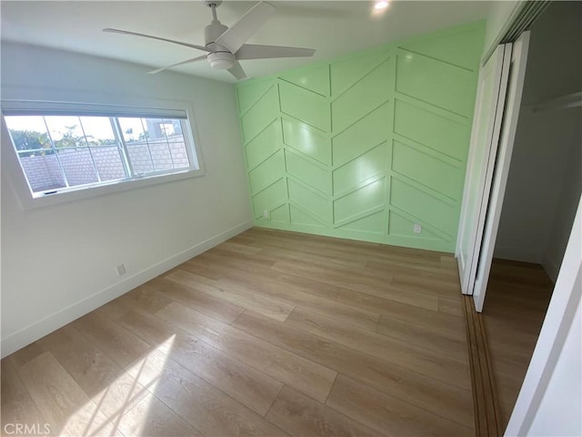 unfurnished bedroom with a closet, light hardwood / wood-style flooring, and ceiling fan