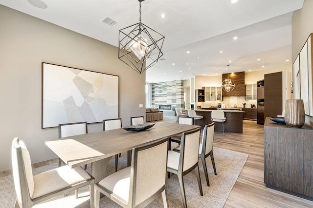 dining room with light hardwood / wood-style flooring and an inviting chandelier