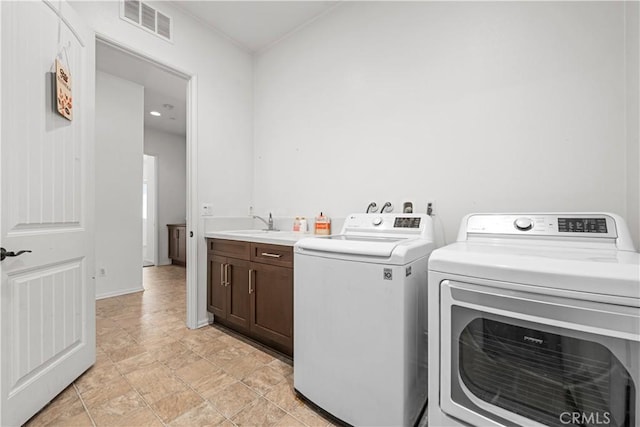 laundry area with cabinets, washer and dryer, and sink