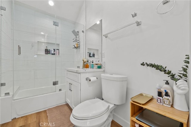 full bathroom with shower / bath combination with glass door, wood-type flooring, vanity, and toilet