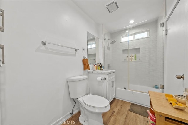 full bathroom with bath / shower combo with glass door, vanity, wood-type flooring, and toilet