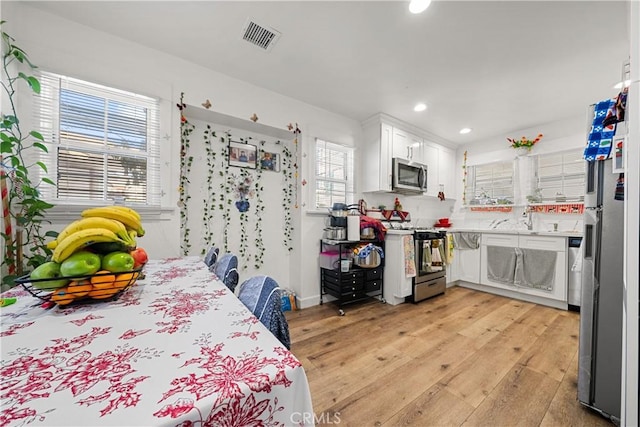 interior space with stainless steel refrigerator, light hardwood / wood-style flooring, and sink