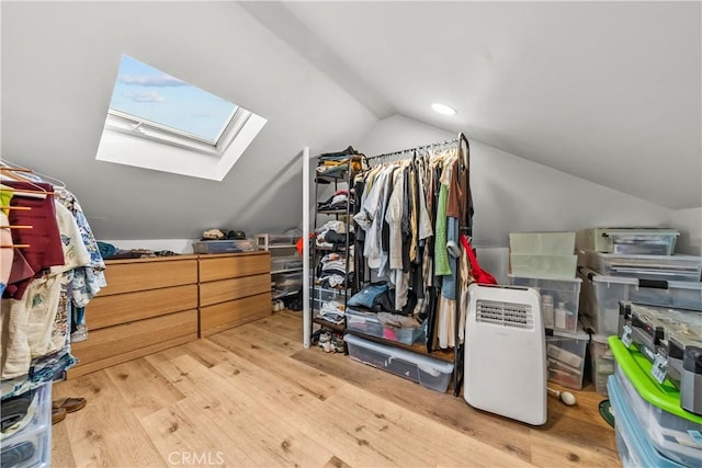 walk in closet with wood-type flooring and lofted ceiling with skylight