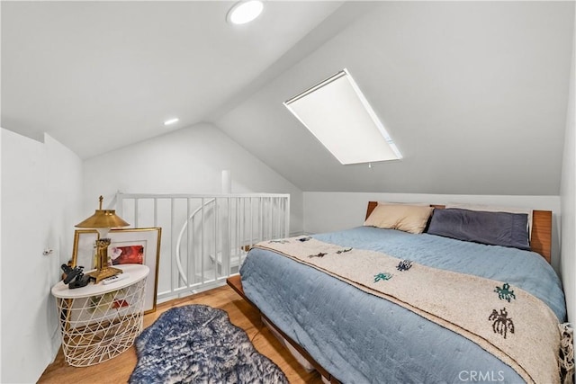 bedroom with hardwood / wood-style floors and lofted ceiling with skylight