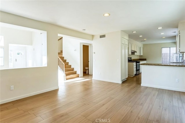 unfurnished living room with sink and light wood-type flooring