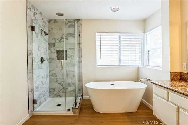 bathroom with wood-type flooring, vanity, and independent shower and bath