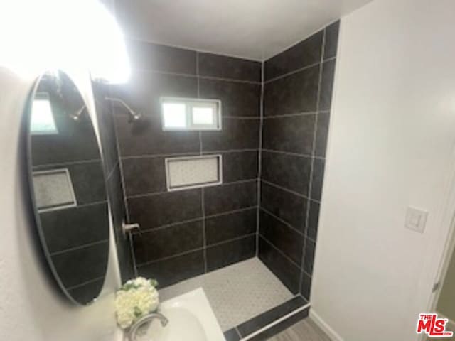 bathroom featuring a healthy amount of sunlight and a tile shower