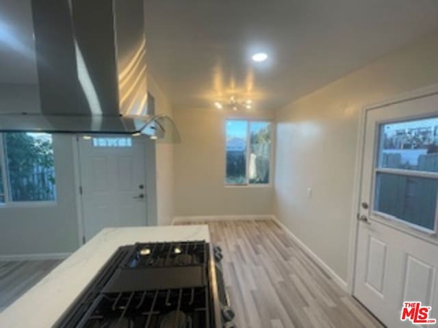 interior space featuring black range, exhaust hood, and light wood-type flooring