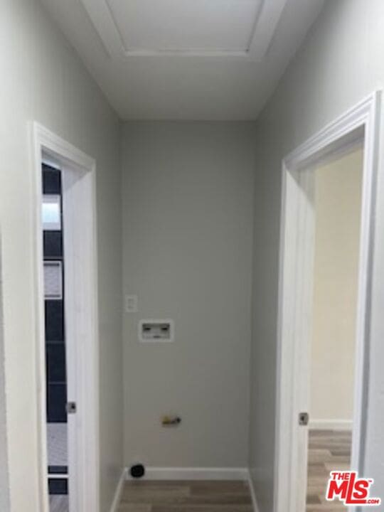 clothes washing area with hardwood / wood-style floors and washer hookup