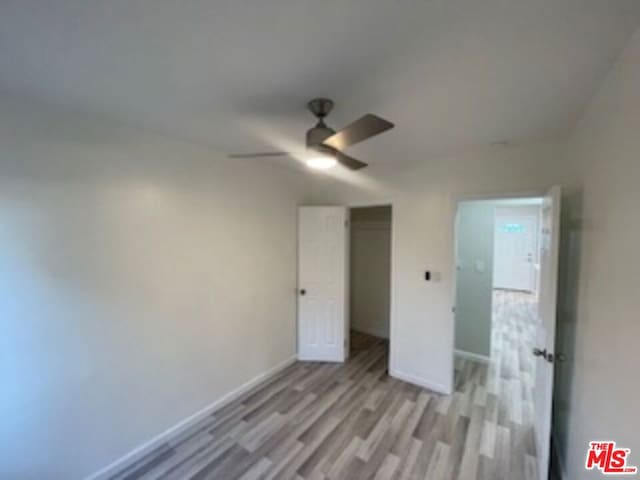 unfurnished bedroom featuring a closet, ceiling fan, and light hardwood / wood-style flooring