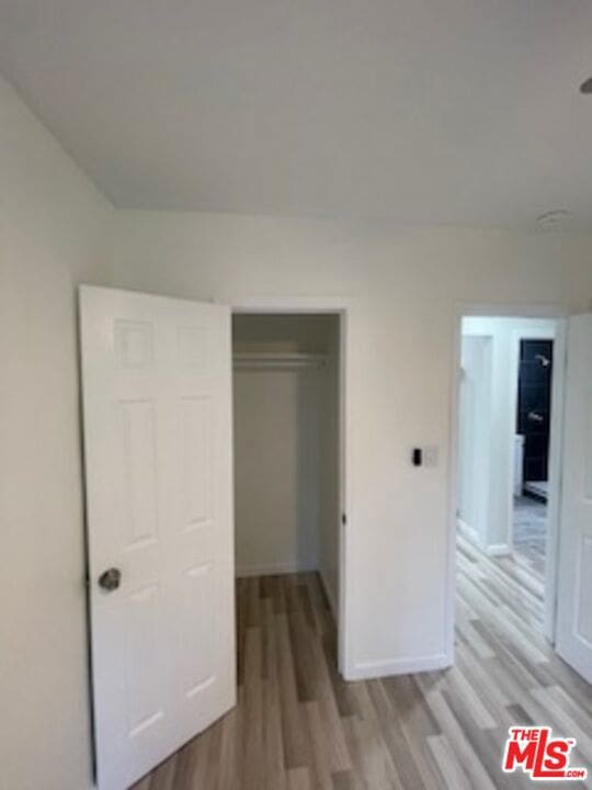 unfurnished bedroom featuring a closet and light wood-type flooring