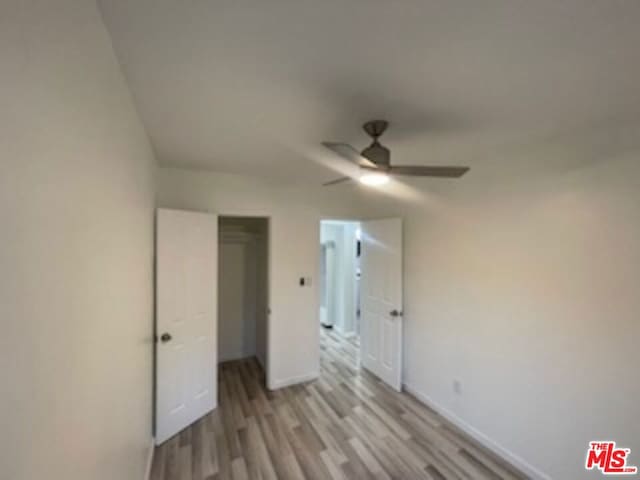 unfurnished bedroom with light wood-type flooring, a closet, and ceiling fan