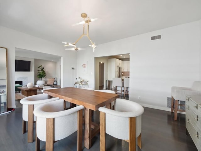 dining space with a notable chandelier and dark wood-type flooring