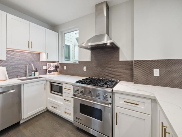 kitchen featuring wall chimney exhaust hood, sink, white cabinetry, and stainless steel appliances