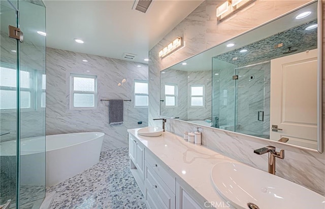 bathroom with independent shower and bath, tile walls, and a healthy amount of sunlight