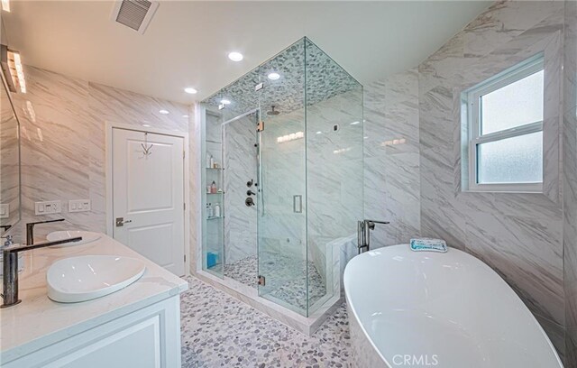 bathroom with vanity, tile walls, and shower with separate bathtub