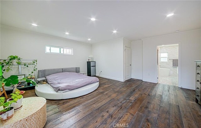 bedroom with dark hardwood / wood-style floors, crown molding, and ensuite bathroom