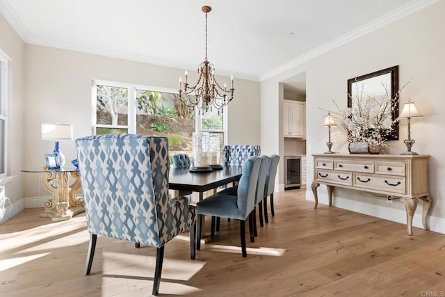 dining room featuring wine cooler, a notable chandelier, crown molding, and light hardwood / wood-style floors