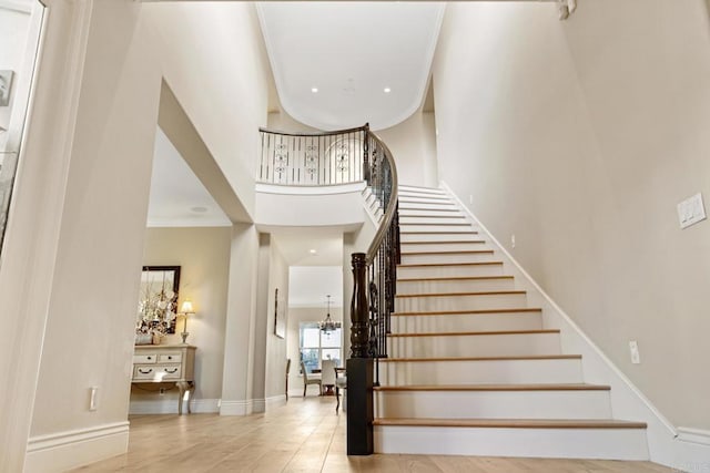 stairs with a high ceiling and crown molding